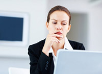 Woman looking closely at computer screen - Peter Barron Stark Companies